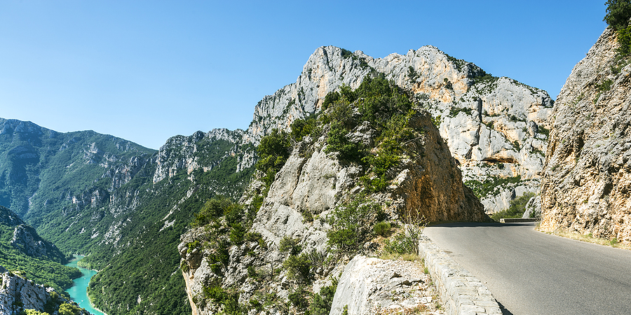 Winding mountain road along the dramatic cliffs of Gorges du Verdon, overlooking turquoise river waters—ideal for motorcycle adventures