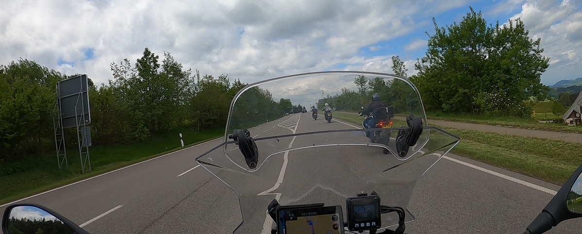 Motorcyclist’s perspective riding along the B500 highway in Germany’s Black Forest, with clear skies, smooth tarmac, and fellow riders ahead