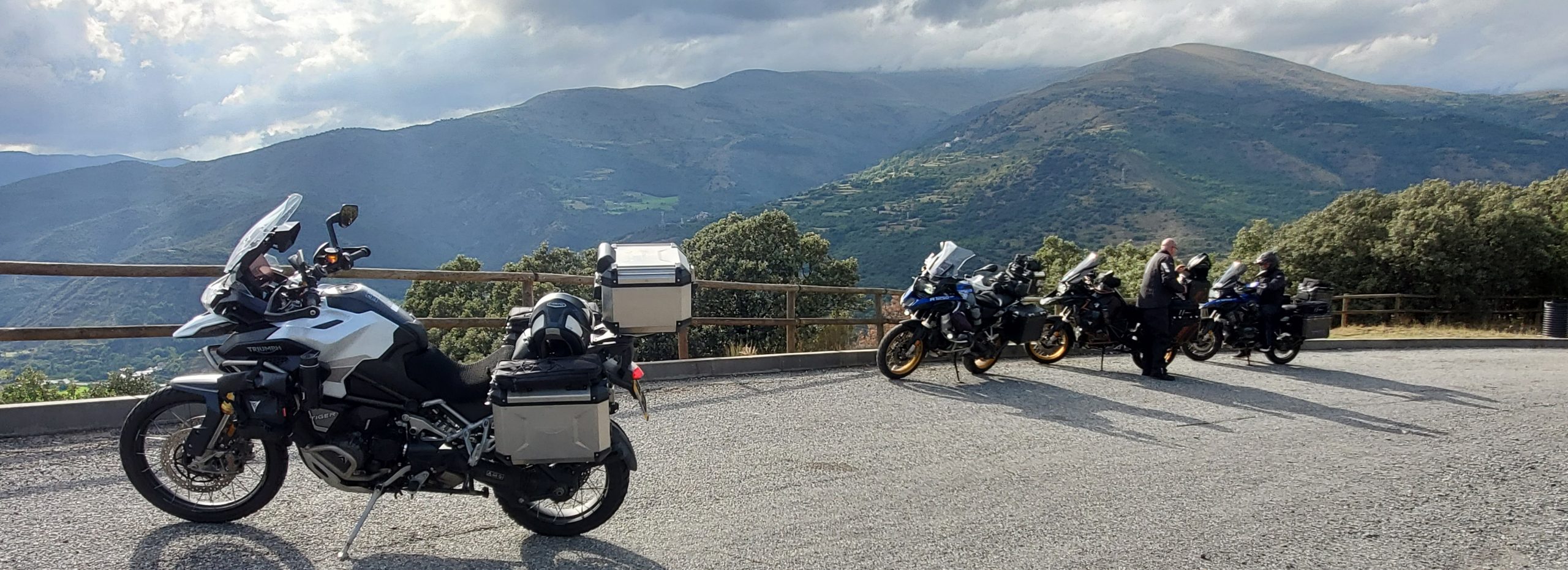 Group of adventure motorcycles parked along the scenic N-260 mountain route in the Pyrenees