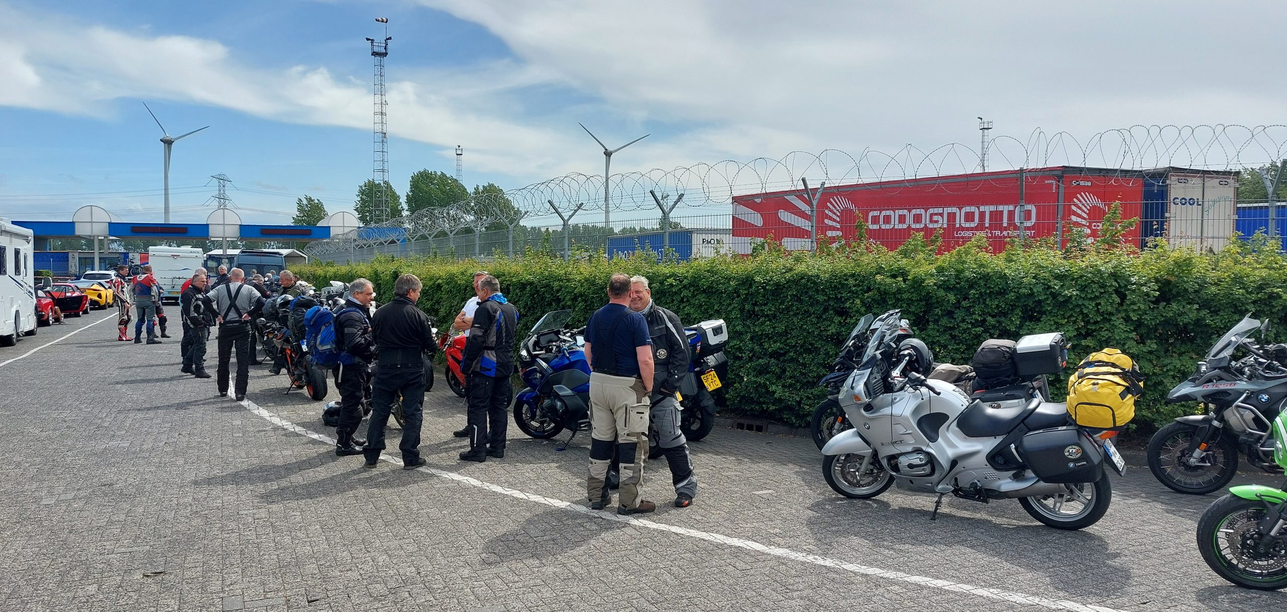 Numerous motorcycles lined up and waiting to board the Rotterdam to Hull ferry, with riders in gear and luggage on their bikes.