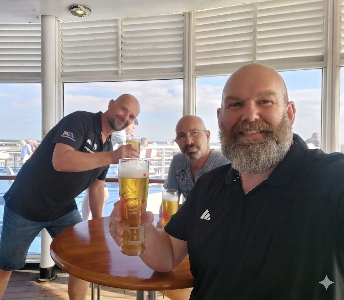 Three smiling men enjoying beers on a ferry deck with the text “5 Day Beginners Tour” above them, marking the start of a motorcycle trip.